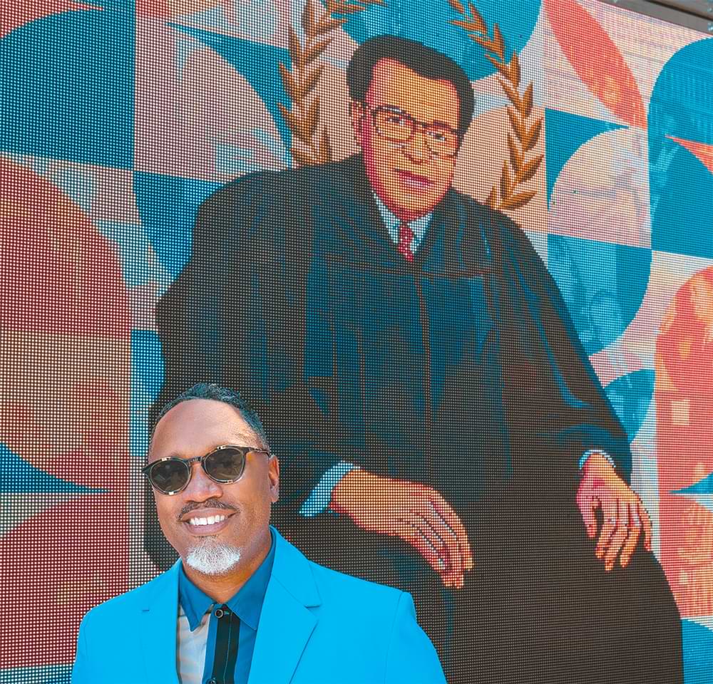 Artist Shawn Theodore with his mural of A. Leon Higginbotham Jr.