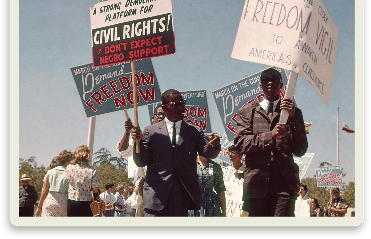 People marching in a civil rights demonstration holding signs reading "Freedom Now" and "Civil Rights."